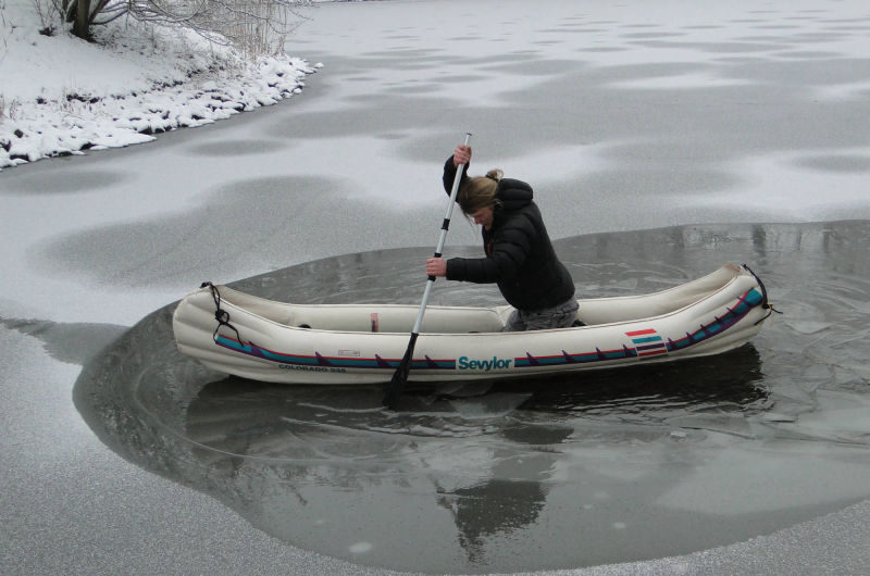 Sebastian im Schlauchboot paddelnd im zugeforenen See